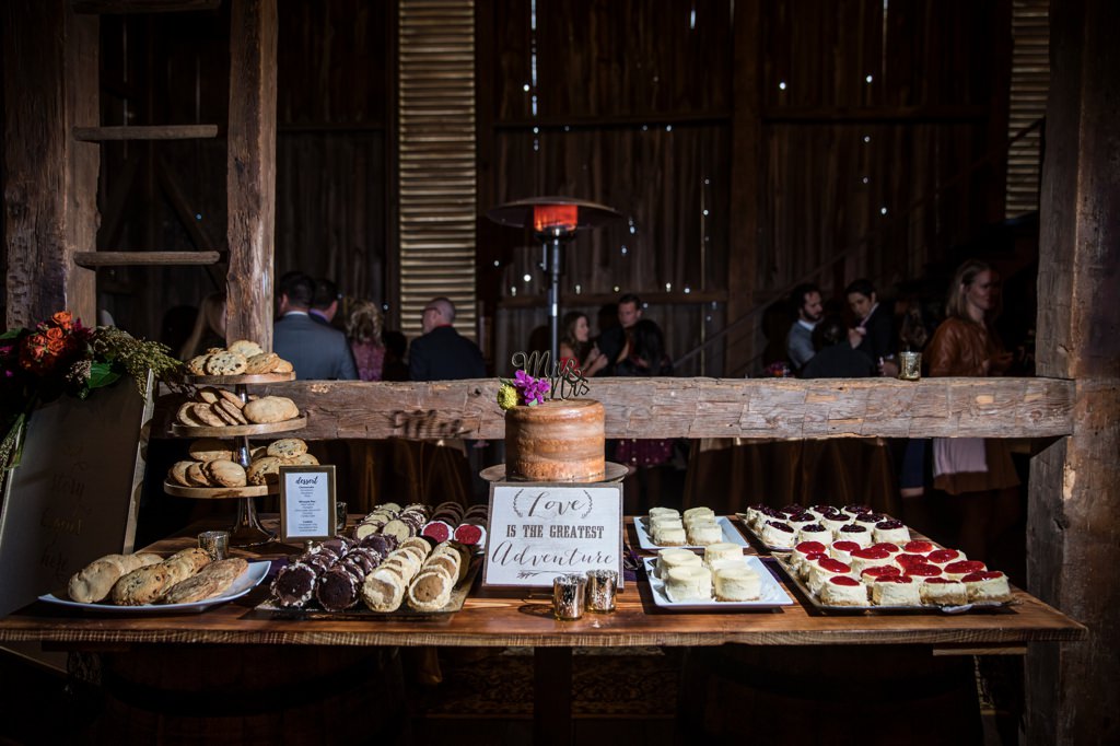 A wedding dessert table filled with cake cookies and whoopie  pies