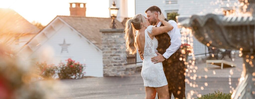 A bride and groom kissing at sunset. This is for the article called wedding expenses you can avoid