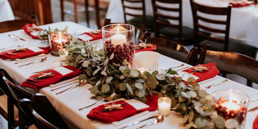 A Christmas wedding centerpiece with cranberries in a candle vase
