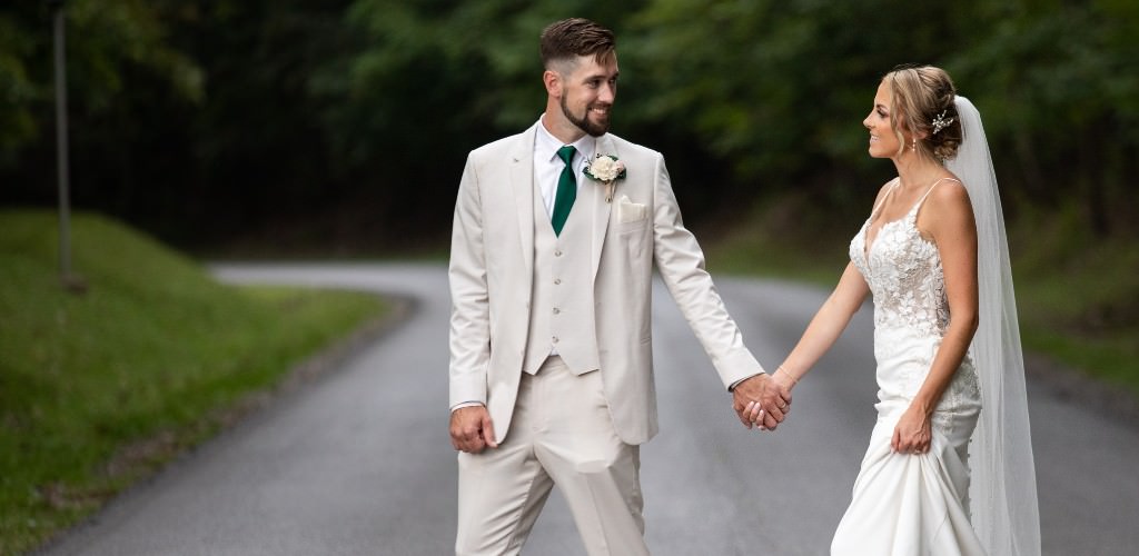 A bride and groom walking across a street