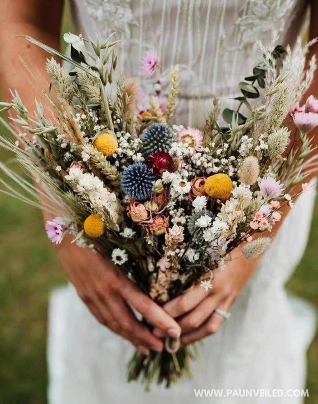 A rustic bridal bouquet made with dried flowers and grasses