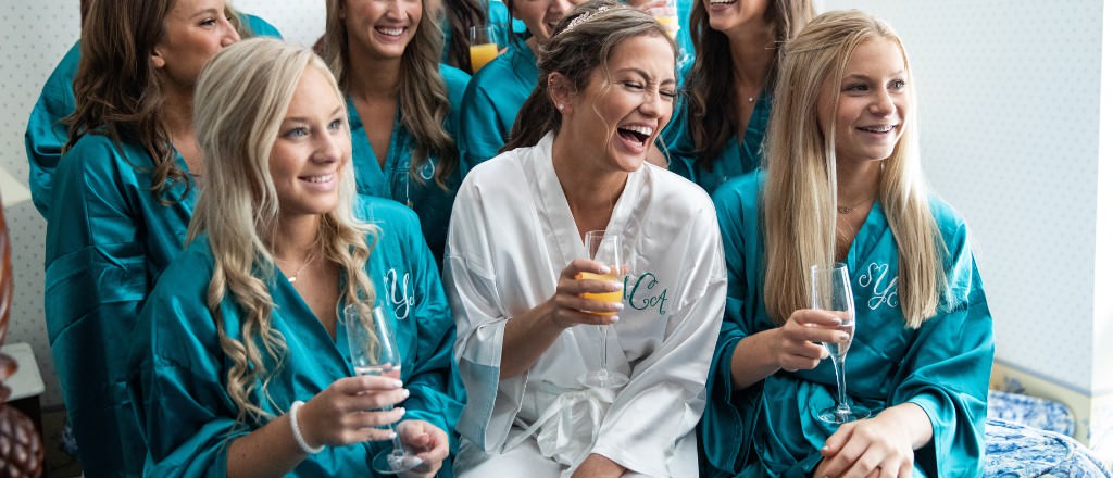 A bride and bridesmaids wearing robes while getting ready