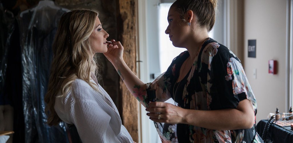 A bride getting her makeup done on the wedding day