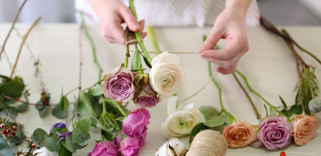 A bride making her own bridal bouquet with some DIY skills she learned from YouTube