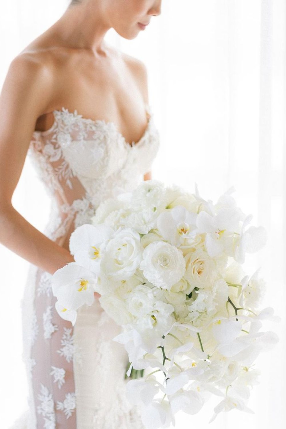 A luxurious all white wedding bouquet with a cascade style