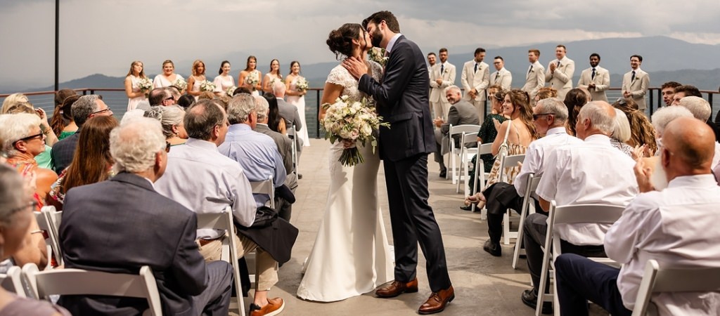 A bride and groom kissing after they walked down the aisle after the wedding ceremony